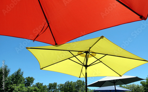 Large sun umbrellas shade patio picnic tables.
