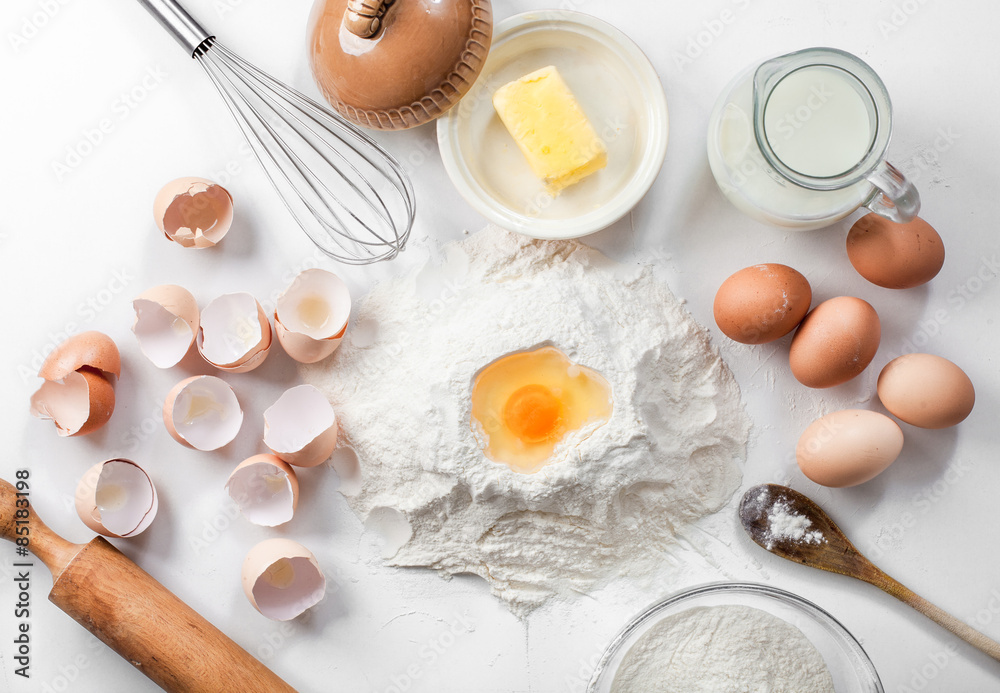 baking background with raw eggs,eggshell, sugar, flour , milk and butter baking background with raw eggs,eggshell, sugar, flour , milk and butter