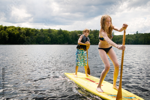 girl and boy on a stand up paddle board