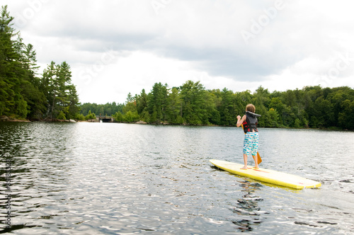 young boy stand up paddle boarding