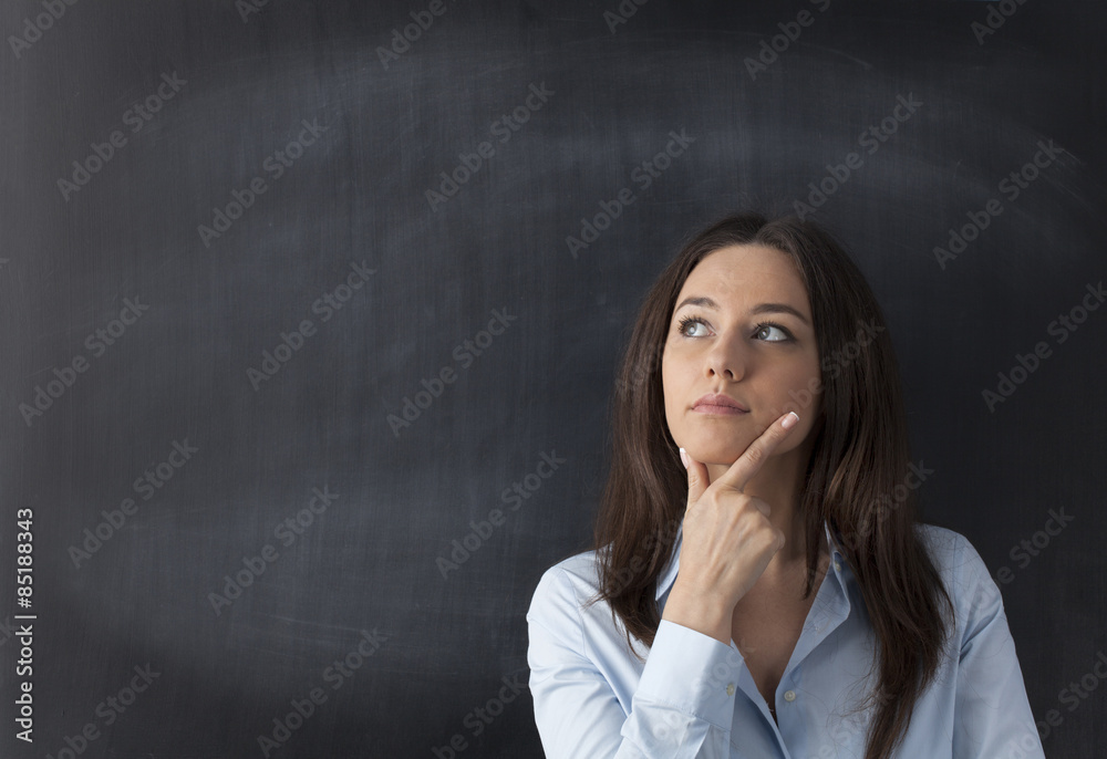 Thoughtful young woman on chalkboard background Thoughtful young woman on chalkboard background
