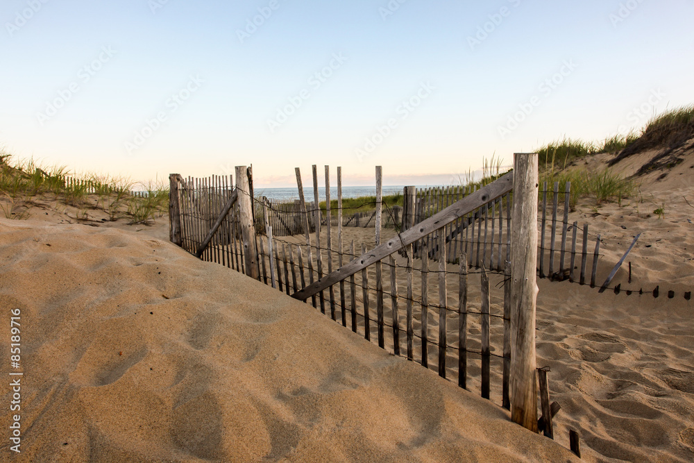 Fence with sand dunes and sky
