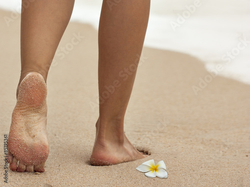 Woman's legs barefoot on sand