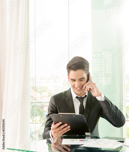 businessman talking via cell phone in office
