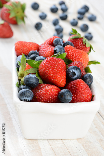 White Bowl of Strawberries and Blueberries on Rustic Table