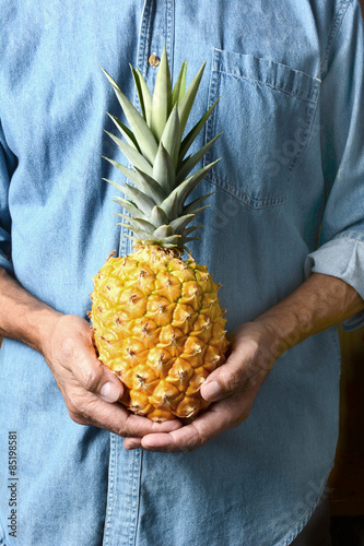 Man Holding Ripe Pineapple