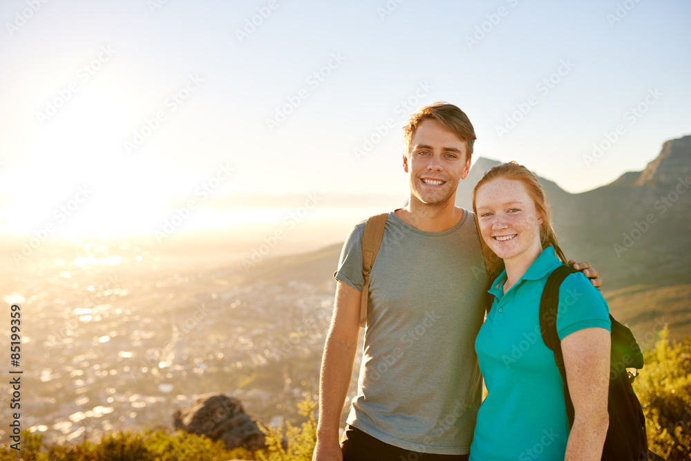 Young couple posing on a hike together with picturesque view