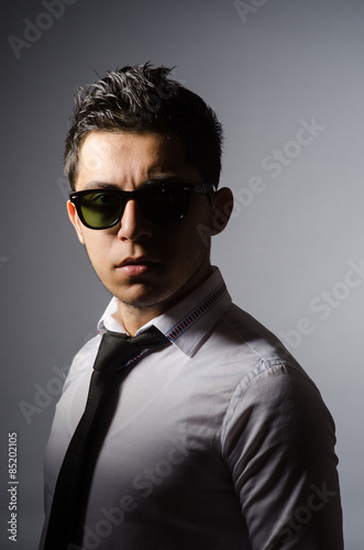 Young man in cool sunglasses isolated on gray