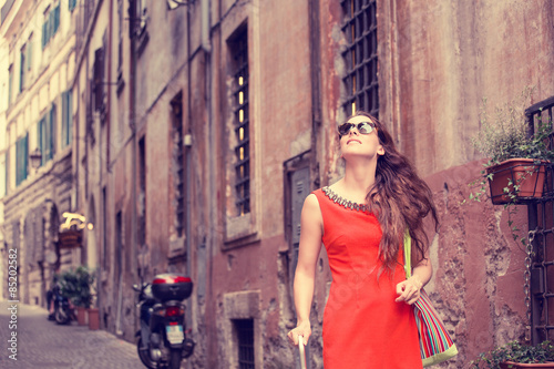 Photography beautiful woman in red summer dress walking smiling in Rome, Italy