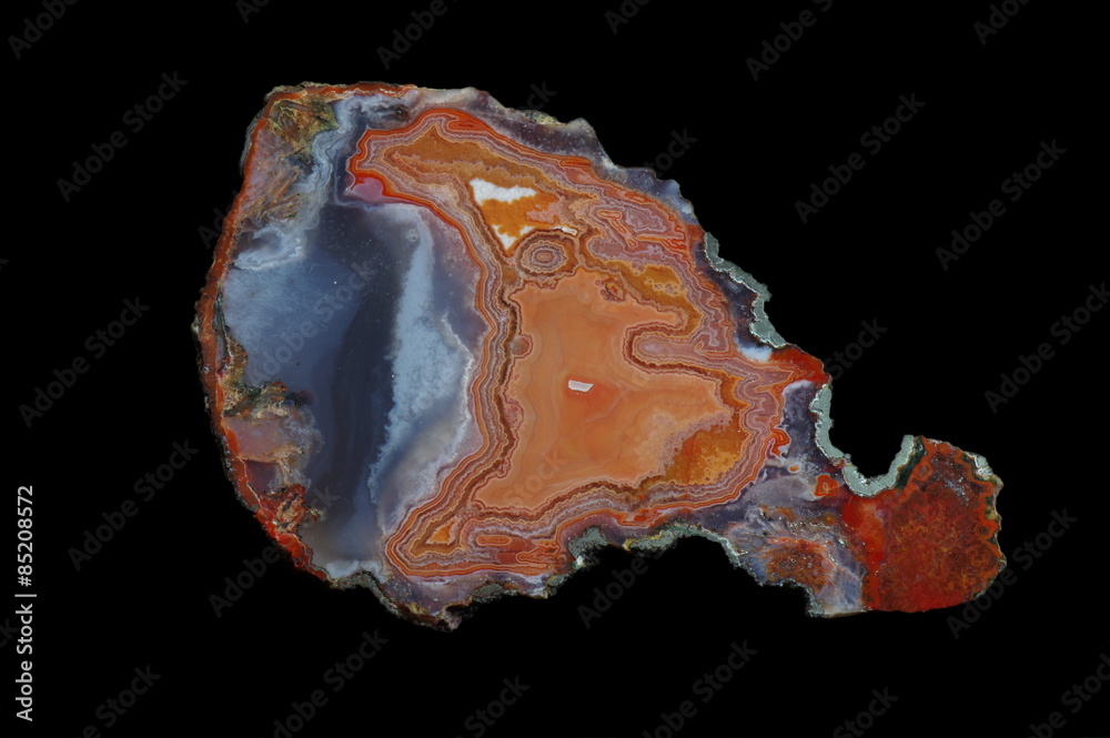 A cross section of agate stone with geode on a black background. Origin: Morocco, Asni. A cross section of agate stone with geode on a black background. Origin: Morocco, Asni.