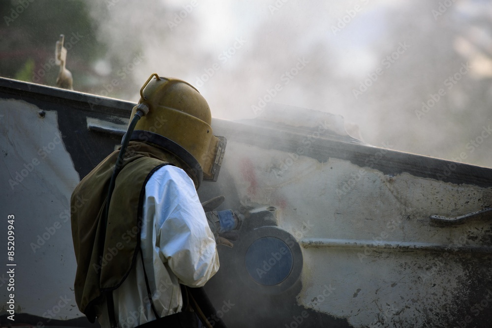 Worker is remove paint by air pressure sand blasting Worker is remove paint by air pressure sand blasting
