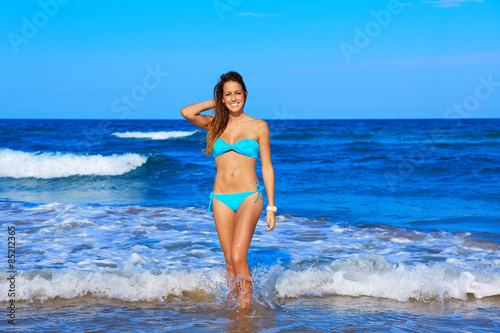 Brunette happy girl walking in the beach shore