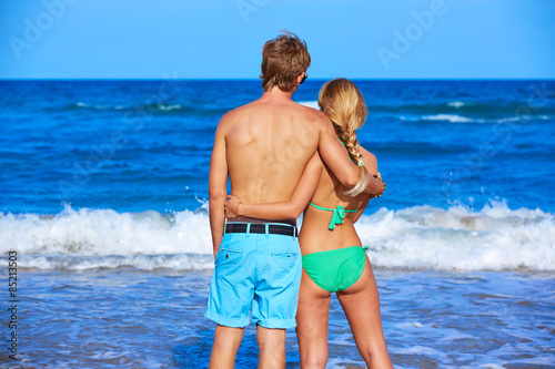 Blond young couple standing looking at the beach