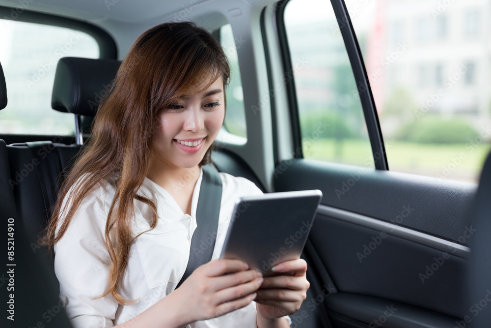 Beautiful asian woman using digital tablet in car