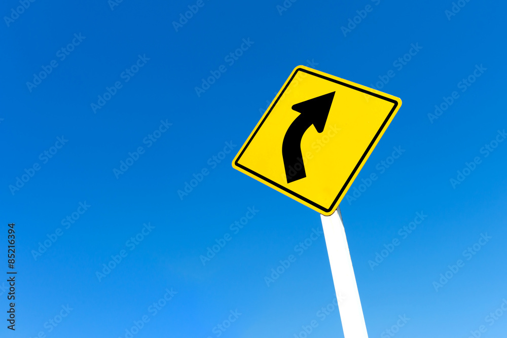 Yellow traffic right curve sign on blue sky background. Yellow traffic right curve sign on blue sky background.