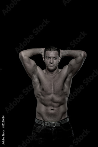  Glamour young handsome athletic man on black background
