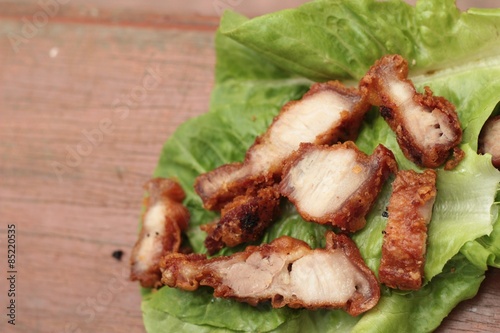 Pork fried with vegetables on wood background.