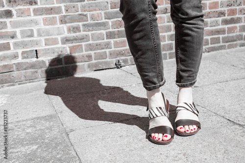 Model wearing black and white sandals with zebra print. 