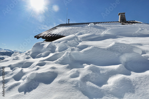 neige recouvrant les abords d'un chalet sous le soleil