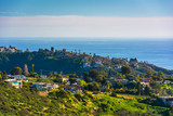 View of green hills and houses overlooking the Pacific Ocean, in
