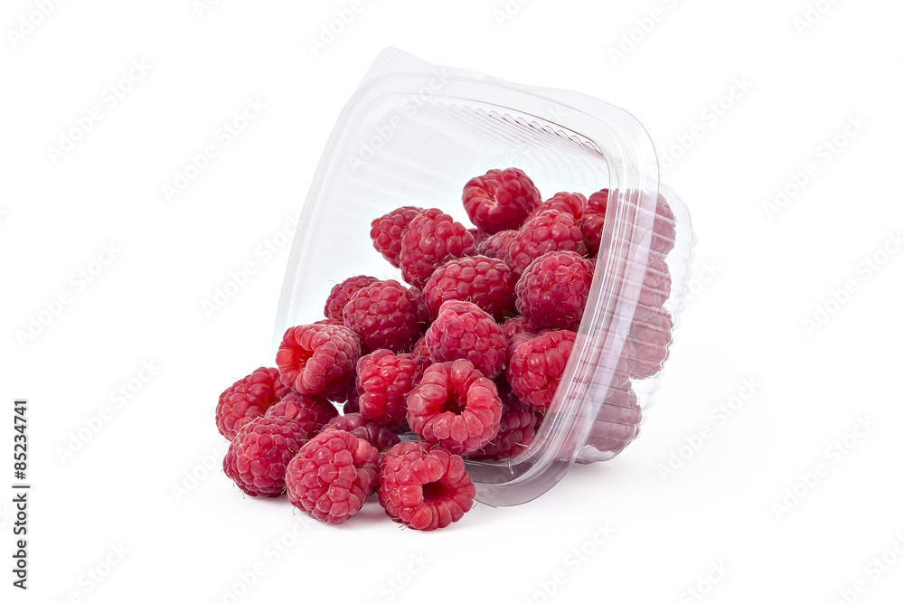 Box or punnet and spilled fresh ripe organic raspberries isolated on white background Box or punnet and spilled fresh ripe organic raspberries isolated on white background