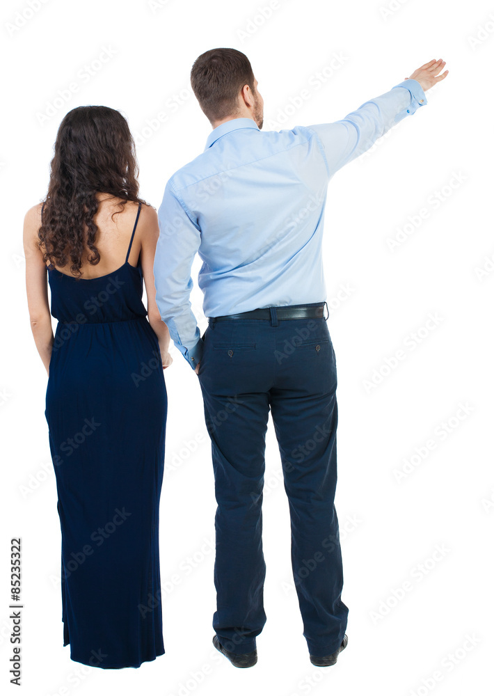 young couple pointing at wal Back view young couple pointing at wal Back view
