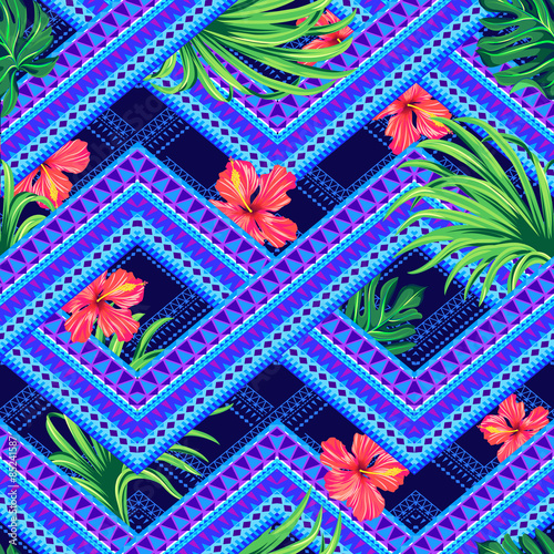 seamless tropical pattern on a tribal background. overlapping geometrical shapes with hibiscus flowers and palm leaves. fashion print
