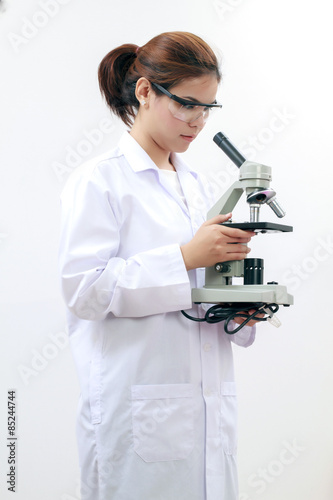 Young female tech or Scientist using a microscope in a laboratory