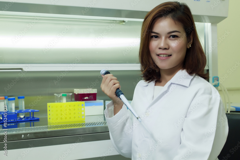 Young female tech or women science working and holding pipette in biological laboratory Young female tech or women science working and holding pipette in biological laboratory