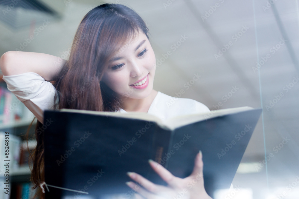 beautiful asian female student reading book in library beautiful asian female student reading book in library