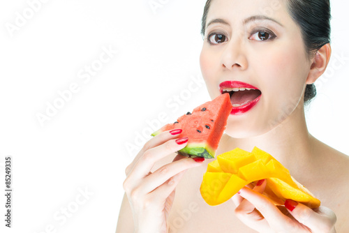 fashion woman eating Tropical fruit, mango, watermelon, bite