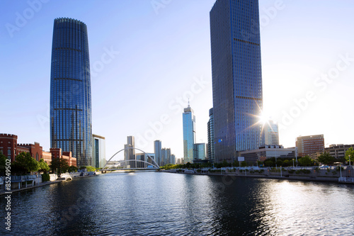 skyscrapers and river in modern city during sunset