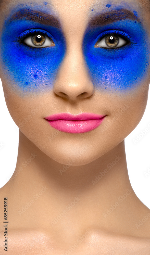 Makeup and beauty theme: portrait of a beautiful young sexy girl with big beautiful eyes, blue shadows on the eyes, pink lipstick on the lips with a smile on isolated white background in studio Makeup and beauty theme: portrait of a beautiful young sexy girl with big beautiful eyes, blue shadows on the eyes, pink lipstick on the lips with a smile on isolated white background in studio