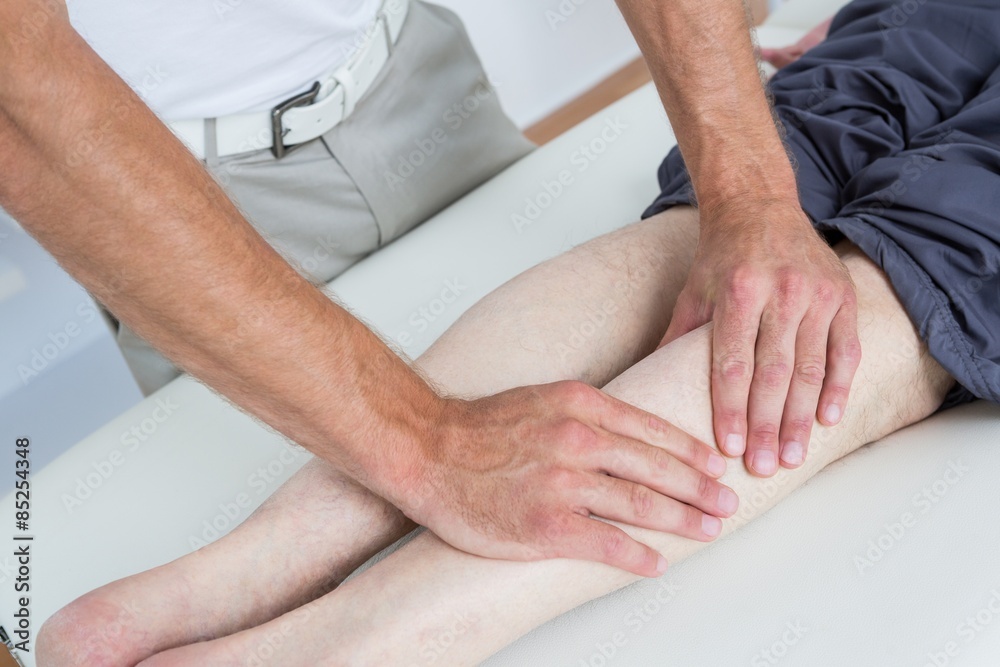 Fototapeta premium Physiotherapist doing leg massage to his patient