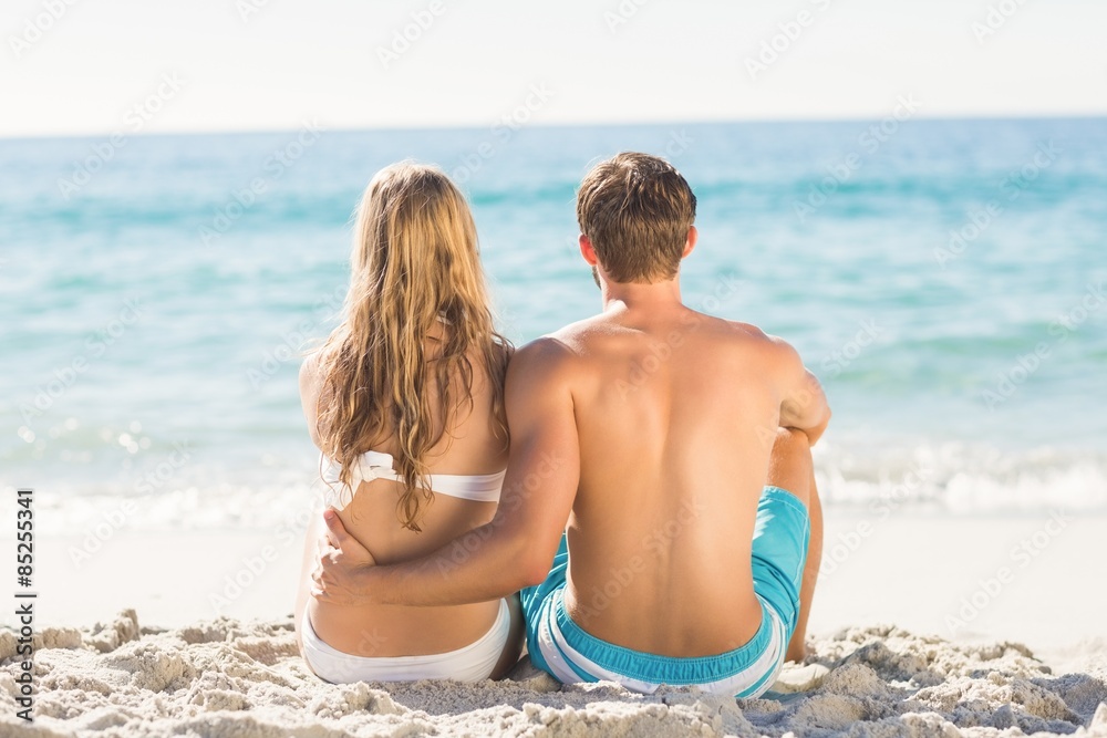 Happy couple relaxing together in the sand Happy couple relaxing together in the sand