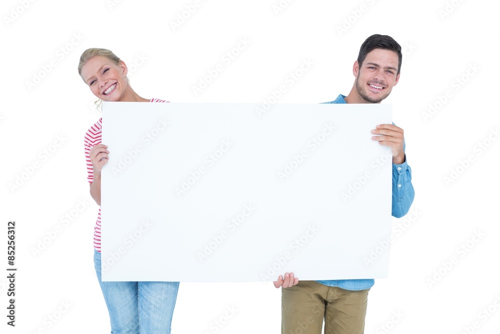 Smiling young couple holding a blank sign Smiling young couple holding a blank sign