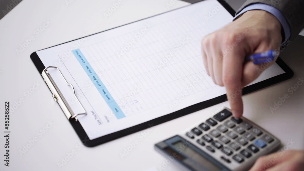 close up of businessman with papers and calculator close up of businessman with papers and calculator