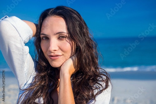 Happy woman looking at camera at the beach