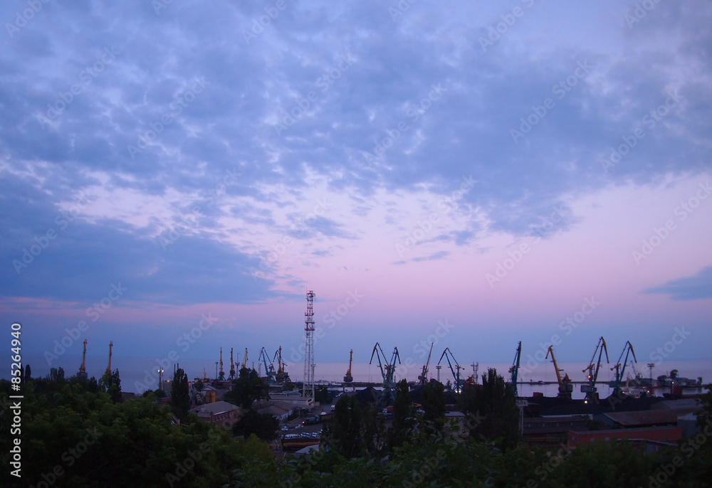 View of a cargo seaport against the evening cloudy sky