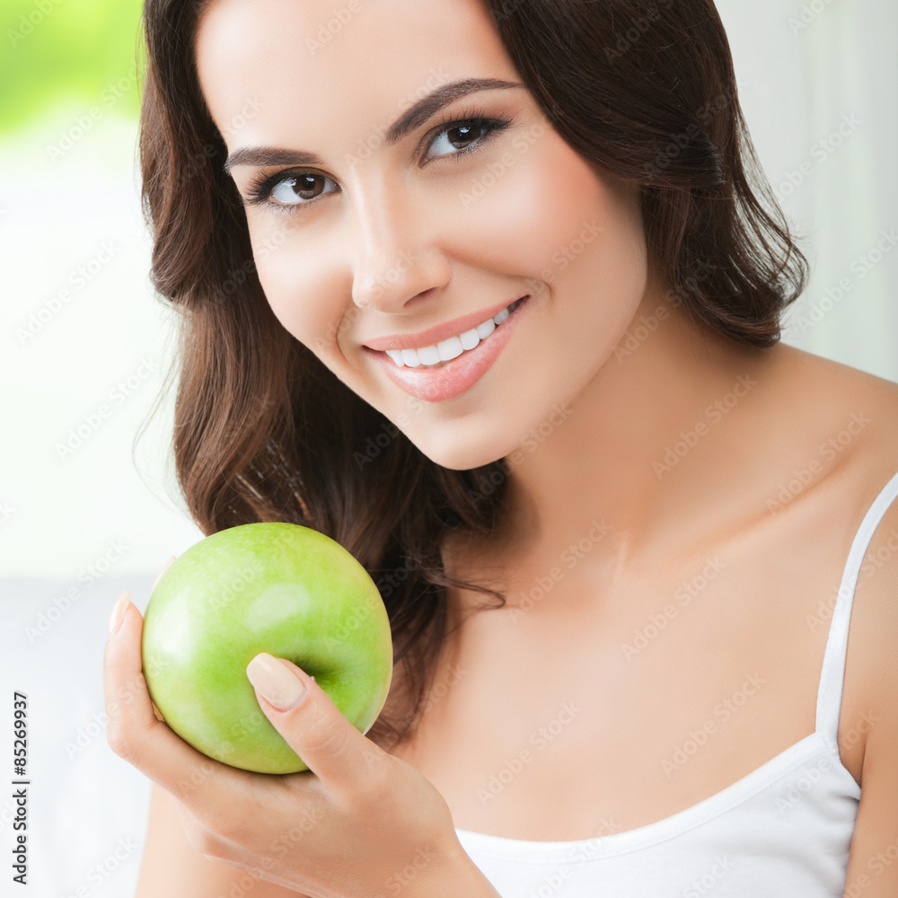 Young happy smiling woman with green apple, indoors Young happy smiling woman with green apple, indoors
