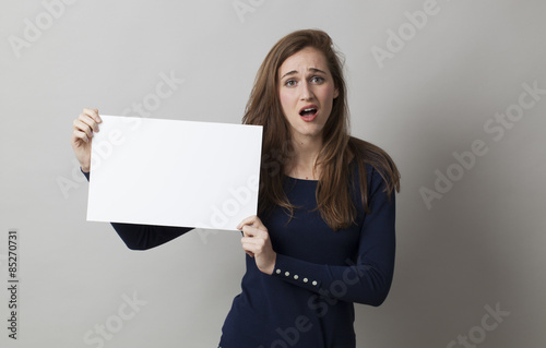 surprised young woman holding a banner with a blank text