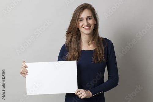 beautiful young girl wearing navy blue holding a claim on blank communication board