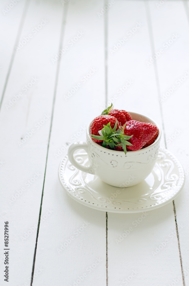 Fresh strawberries in a rustic cup on wooden table Fresh strawberries in a rustic cup on wooden table