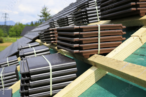 A roof under construction. Stacks of tiles ready to be fasten.