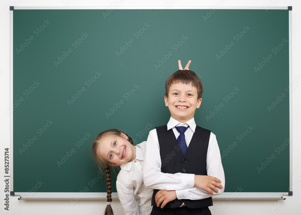 Schoolboy and schoolgirl near the school board Schoolboy and schoolgirl near the school board