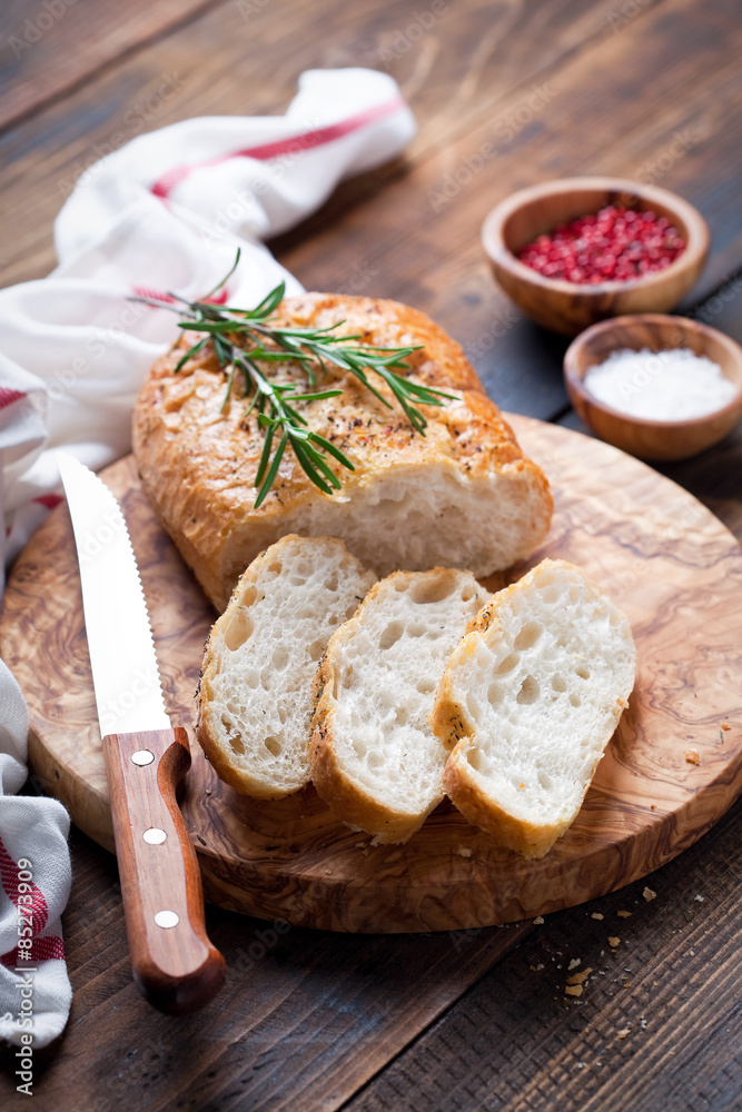Ciabatta with rosemary on a wooden board, selective focus