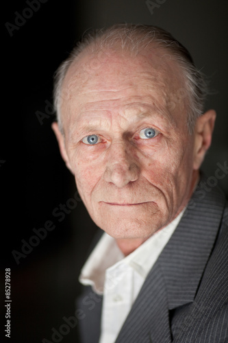 Portrait of a balding blue eyed senior gentleman.