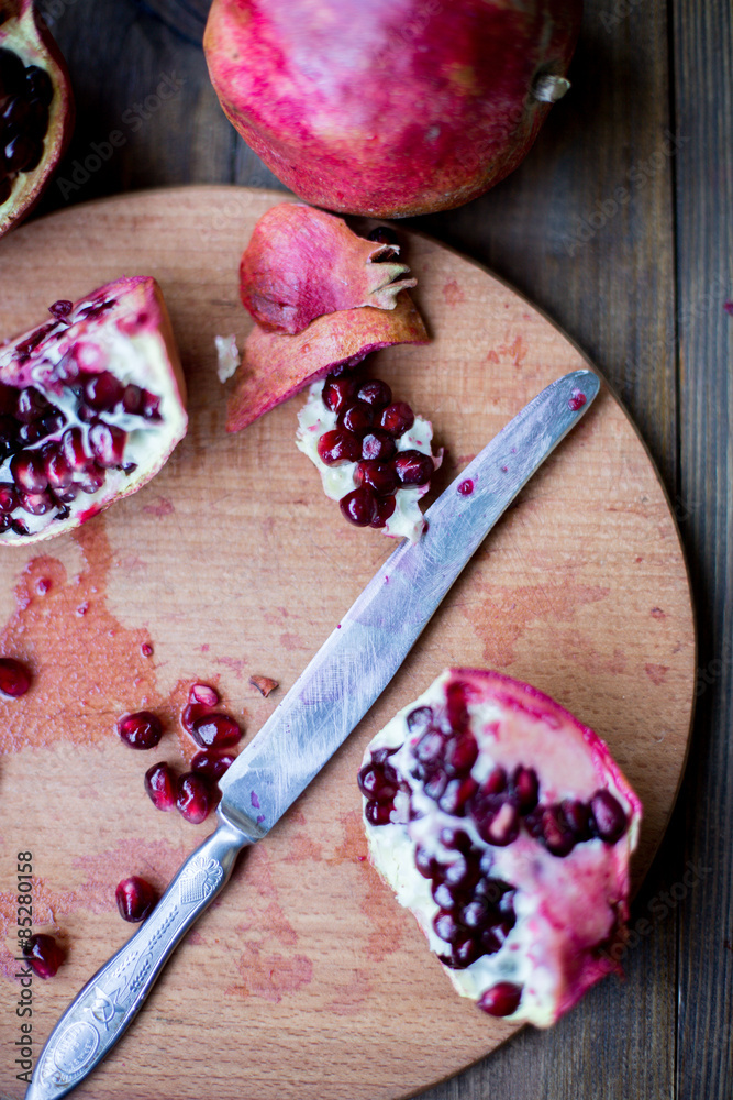 organic pomegranate open cut in half and full one on a wooden dark table background decorated in rustic style organic pomegranate open cut in half and full one on a wooden dark table background decorated in rustic style