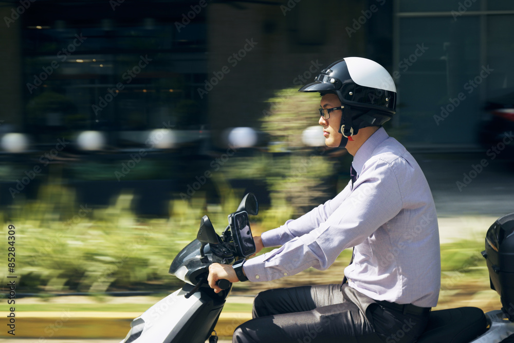 Obraz premium Chinese Businessman Commuter Riding Scooter Motorcycle In City