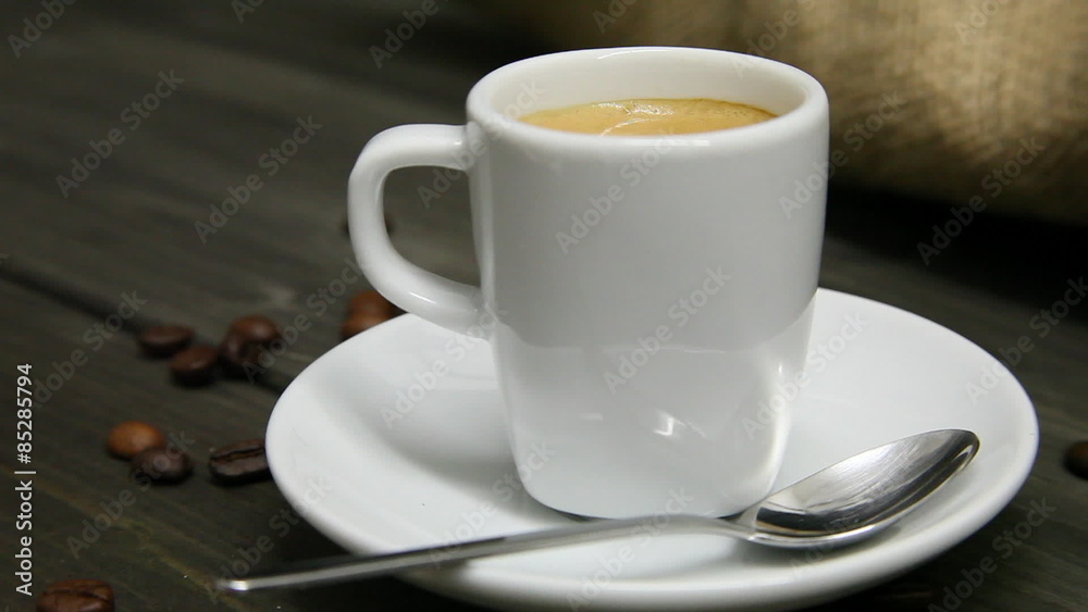 Camera ride from glass of coffee beans to a fresh brewed cup of espresso Camera ride from glass of coffee beans to a fresh brewed cup of espresso